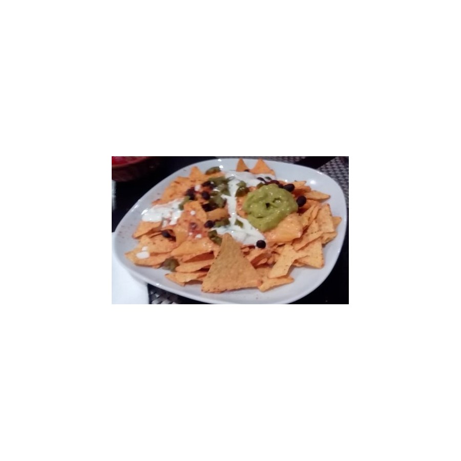 Croccanti triangolini di tortilla di mais serviti con salsa guacamole, fagioli neri e formaggio fuso.